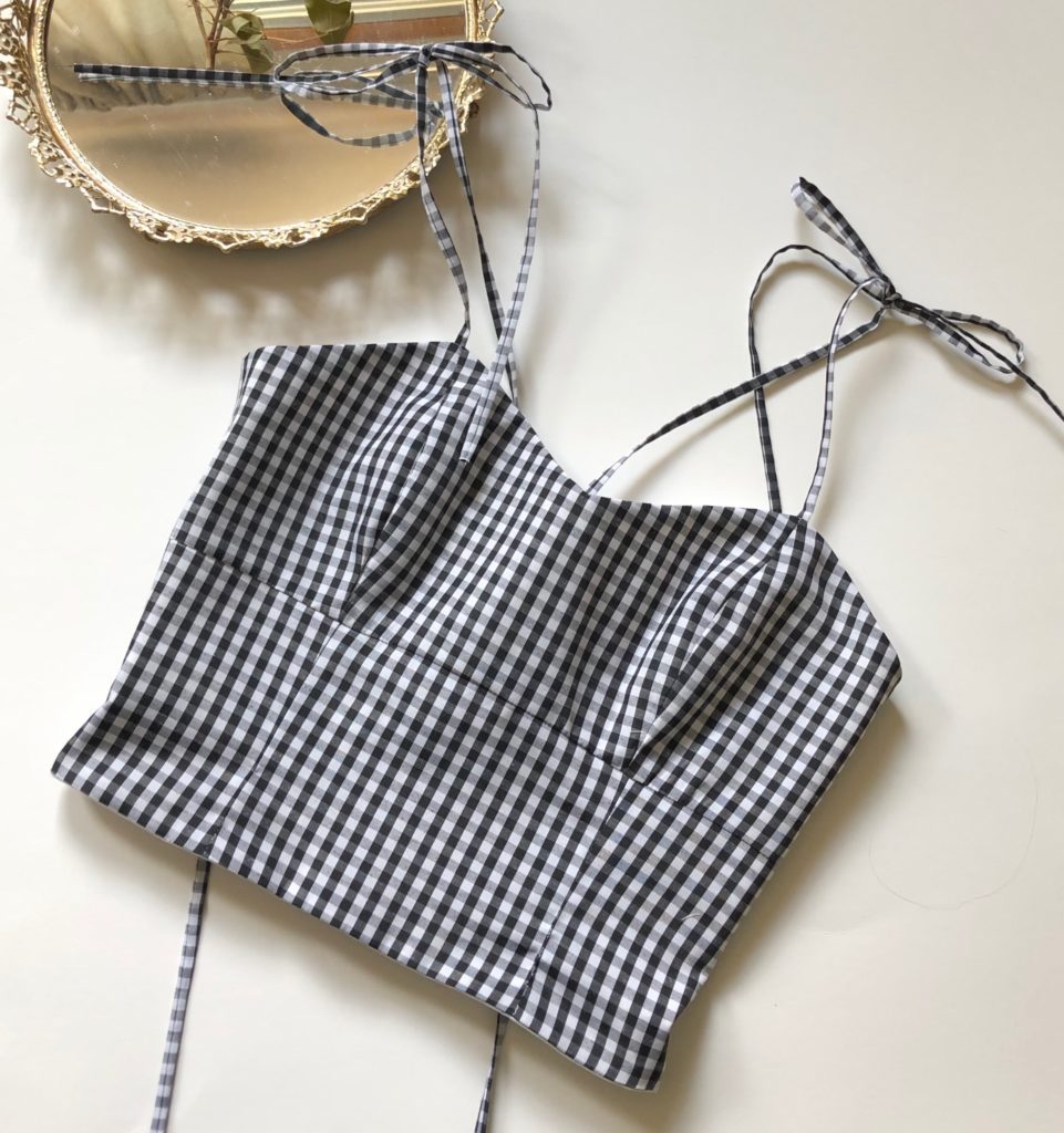 flat lay front view of gingham crop top with skinny straps that tie at the shoulder
